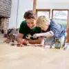 Two children are playing with LEGOs on the floor. Anteprima dell’immagine prodotto