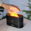 A hand is held over a black humidifier with a flame-like mist effect. Voir les images du produit
