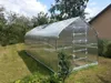 A greenhouse is set up in a grassy yard with trees and a house in the background. Anteprima dell’immagine prodotto