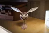 A wooden 3D puzzle of a Golden Snitch from Harry Potter is displayed on a wooden shelf. Náhled obrázku produktu