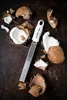 A grater and broken coconut pieces on a dark surface. Anteprima dell’immagine prodotto