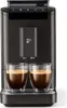 A dark gray Tchibo coffee machine with two cups of espresso in front of it. Produktbild-Vorschau