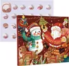 A Christmas advent calendar with a festive design featuring Santa Claus, a snowman, and reindeer, alongside a separate white tray containing small jewelry items visible through circular openings. Produktbild-Vorschau