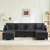 A U-shaped sectional sofa with multiple cushions and ottomans is shown in a living room setting. Anteprima dell’immagine prodotto