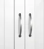 A close-up view of two silver cabinet handles on a white cabinet. Produktbild-Vorschau
