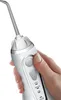 A hand holding a white cordless water flosser. Produktbild-Vorschau