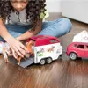 A young girl is playing with a toy horse trailer and car. Produktbild-Vorschau