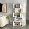 A white, multi-level bookshelf filled with books and decorative items, placed in a living room setting next to a sofa and a plant. Anteprima dell’immagine prodotto