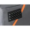A close-up view of a section of a dog transport box, showing a black textured patch with pyramid-like studs and an orange trim. Produktbild-Vorschau