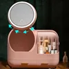 A pink makeup organizer with a mirror and drawers, filled with cosmetic products. Anteprima dell’immagine prodotto