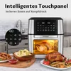 A silver and black air fryer is shown in a kitchen setting, with food items like a whole roasted chicken and french fries displayed in the foreground. Produktbild-Vorschau