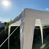 A white gazebo tent is set up outdoors on a sunny day, with trees and a fence visible in the background. Produktbild-Vorschau