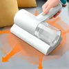 Weißer Handstaubsauger, der von einer Hand benutzt wird, um ein graues Sofakissen zu reinigen, mit orangefarbenen Pfeilen, die die Saugkraft anzeigen Náhled obrázku produktu