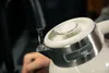 Water pouring from a faucet into a kettle. Podgląd zdjęcia produktu