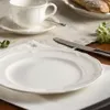A table setting with a plate, cup, saucer, and cutlery. Podgląd zdjęcia produktu