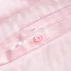 A close-up view of pink striped bedding with a button closure. Náhled obrázku produktu