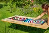 A woman playing a colorful curling game on a wooden table in a garden. Produktbild-Vorschau