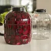 Two large plastic jars, one filled with red liquid and sliced beets, sit on a table. Produktbild-Vorschau