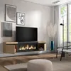 A modern living room with a wall-mounted TV stand featuring an electric fireplace, artwork on the wall, and a floor lamp. Produktbild-Vorschau