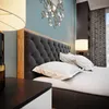 A bedroom scene with a bed, nightstand, and lamp. Produktbild-Vorschau