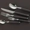 A set of cutlery arranged on a dark brown surface. Voir les images du produit