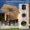 An outdoor patio scene at dusk with a beige umbrella and table setting. Produktbild-Vorschau