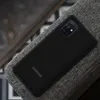 A black Samsung phone case is shown on a textured gray surface. Anteprima dell’immagine prodotto