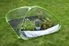 A pop-up greenhouse with plants inside, set up on a lawn. Náhled obrázku produktu