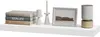 A shelf with decorative items including books, candles, a picture frame, and a speaker. Produktbild-Vorschau