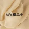 Laundry care symbols are shown on a draped fabric. Produktbild-Vorschau