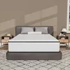 A mattress is displayed on a bed frame in a bedroom setting, with nightstands on either side. Produktbild-Vorschau