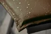 Close-up of a brown fabric with water droplets on it, resting on a black frame. Produktbild-Vorschau