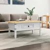 A white coffee table with a wooden top is placed in a living room setting, in front of a sofa. Náhľad obrázku produktu
