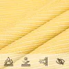 A close-up of beige fabric with a textured weave, overlaid with three icons representing water resistance, sun protection, and wind resistance. Produktbild-Vorschau