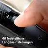A close-up shot of a person's finger adjusting a dial on a black electronic device, likely a grooming tool. Produktbild-Vorschau