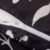 A close-up view of a black duvet cover with a white leaf pattern, showing a partially open zipper. Náhled obrázku produktu