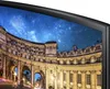 A close-up view of a curved screen displaying a night sky over an ornate building. Produktbild-Vorschau