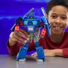 A young boy is smiling and holding a blue and gray robot toy. Anteprima dell’immagine prodotto