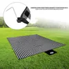 A picnic blanket spread out on a grassy field with trees in the background. Produktbild-Vorschau