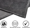Close-up of a gray blanket with care instructions icons below. Produktbild-Vorschau