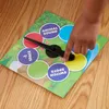 A hand is shown spinning the spinner on a TWISTER Junior game board. Náhled obrázku produktu