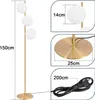 A floor lamp with three white globe lights and a gold stem and base, shown with dimension callouts. Podgląd zdjęcia produktu