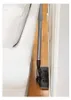 A vacuum cleaner attachment is shown cleaning a narrow space between a couch and a wall. Voir les images du produit