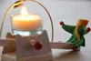 A close-up of a candle and a small wooden and felt craft project. Anteprima dell’immagine prodotto