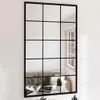 A large, black-framed mirror with a grid design, reflecting a living room scene with a sofa and a window. Anteprima dell’immagine prodotto