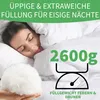 A woman sleeping comfortably under a white duvet, with a pile of filling material in the foreground and a graphic indicating weight. Produktbild-Vorschau
