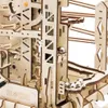A close-up view of a wooden marble run construction kit, showing several silver marbles on tracks and gears. Voir les images du produit