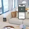 A modern living room with a humidifier and a smartphone displaying its app control interface. Náhled obrázku produktu