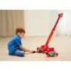 A young boy is playing with a toy fire truck with a ladder. Produktbild-Vorschau