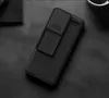 A black phone case with a sliding camera cover is shown on a dark, textured surface. Podgląd zdjęcia produktu